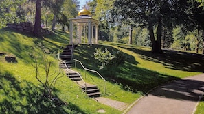 Ein Pavillon mit goldener Kuppel, einer Steinmauer und einer Treppe, die dorthin führt.