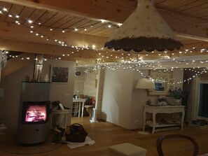 Ein gemütliches Zimmer mit Kamin, Holzbalken und Lichterketten.