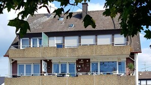 A multi-story residential building with balconies, windows, and a garage. - Holiday Apartment 'Haus Abendsonne Upper Floor Small' with Shared Terrace, Balcony and Wi-Fi (Koblenz)