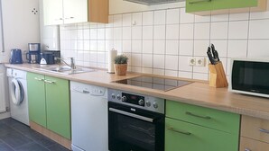 Una cocina compacta con lavavajillas, horno y microondas.