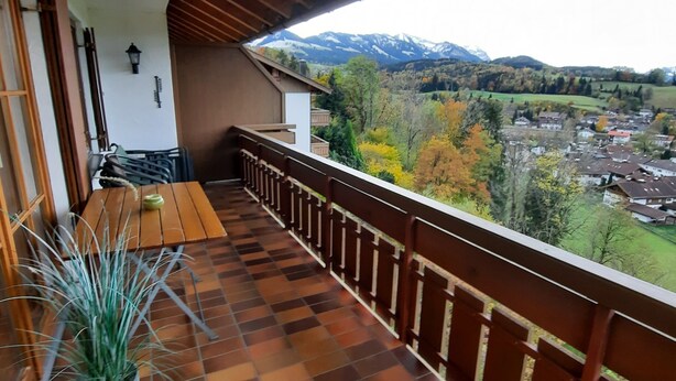 Een balkon met uitzicht op een stad en bergen.