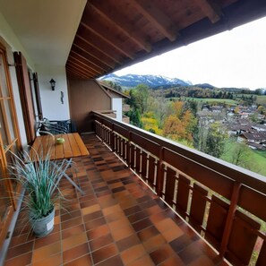 Un balcón con vistas a un pueblo y montañas.