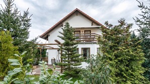 A two-story house with a balcony, surrounded by greenery. - Holiday Apartment 'Omatina' with Balcony and Wi-Fi (Bannewitz)