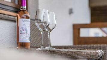 Une bouteille de vin et deux verres posés sur une surface en osier.