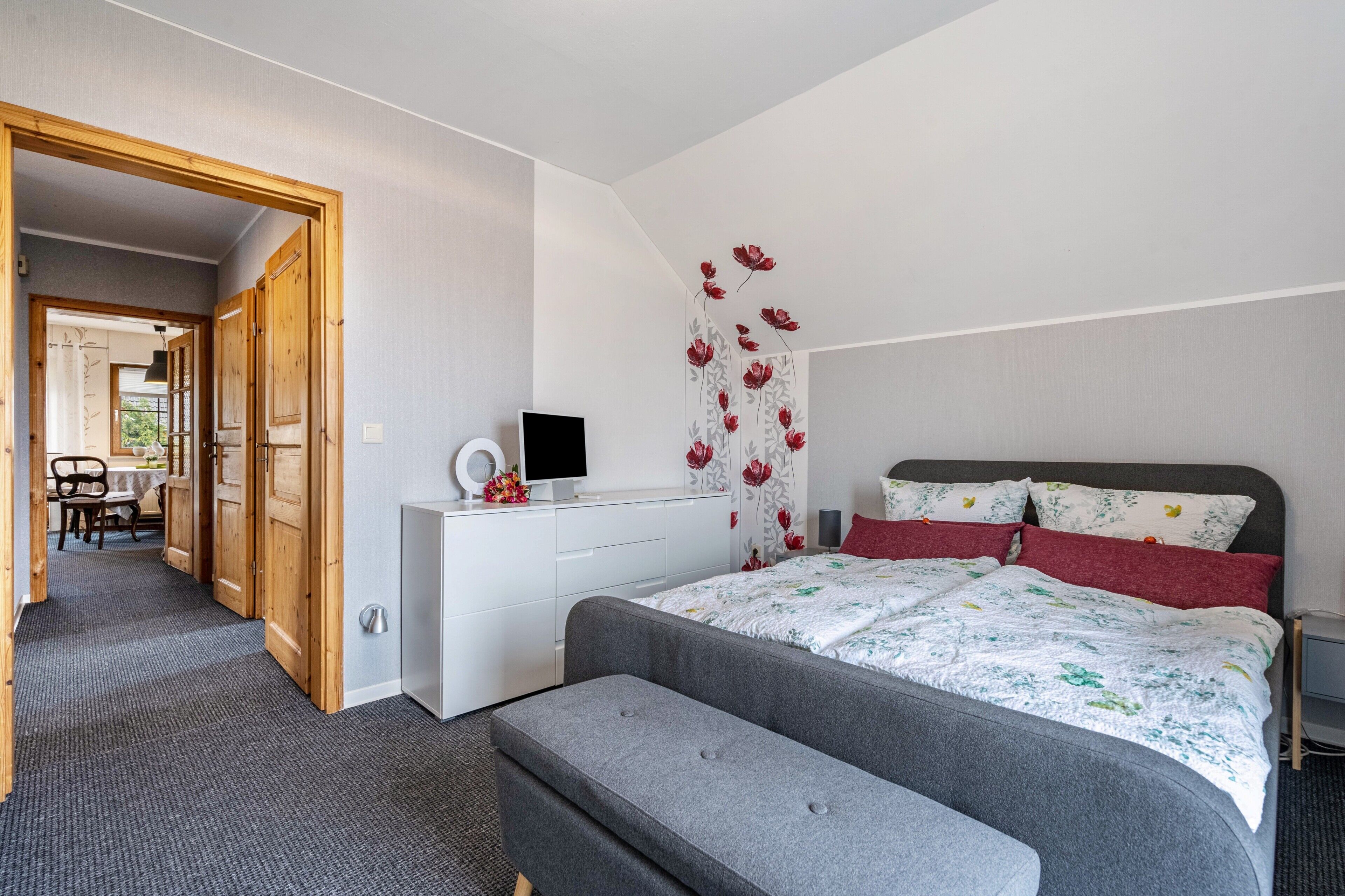 Una camera da letto con un letto, un comodino e una scrivania con una sedia.