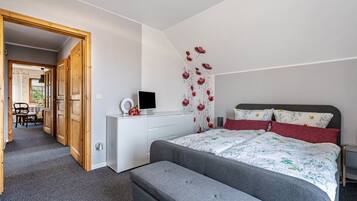 Una camera da letto con un letto, un comodino e una scrivania con una sedia.