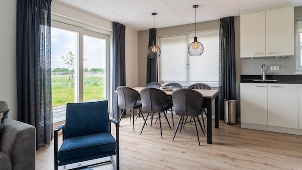 Een moderne keuken met witte kasten, een zwart aanrecht en een RVS-spoelbak.