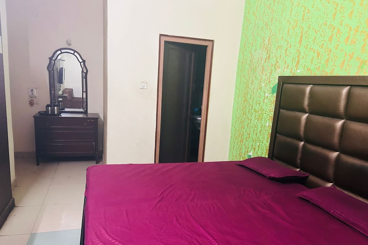 A bedroom with a bed, a dresser, and a mirror.