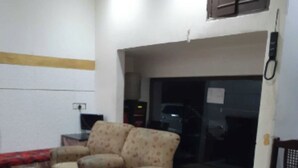 Ein Wohnzimmer mit einer Couch, einem Glastisch und einem Teppich mit Muster.