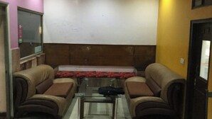 Ein Zimmer mit zwei Sofas, einem Glastisch und einem Deckenventilator.