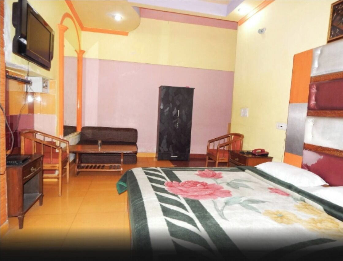 A hotel room with a bed, a television, a desk, and a chair.