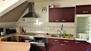 A kitchen with a stove, sink, and cabinets. - Ferienwohnung in Lauterbach im Schwarzwald (Lauterbach)