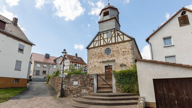 A traditional stone building with a wooden door and steps leading to a small porch. - Nature Escape in Fuldabruck (Fuldabrück)