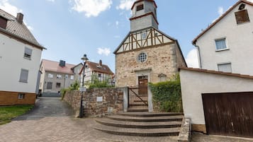 A traditional stone building with a wooden door and steps leading to a small porch.