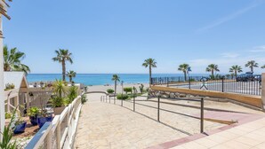 Ein Strandgrundstück mit einem steinernen Weg zum Strand, Palmen und freiem Blick auf den Ozean.