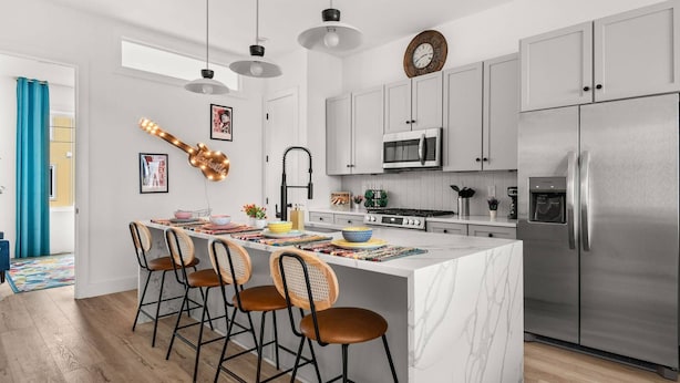 Uma cozinha moderna com ilha central, eletrodomésticos de aço inoxidável e um design amplo e iluminado.