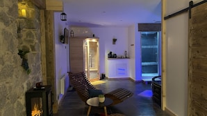 Un intérieur moderne avec un mur en pierre, un banc en bois, une petite table et une cheminée.