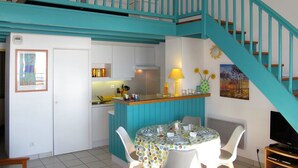 Una cucina con zona pranzo, una scala e un cartello con la scritta 'Ocean'.