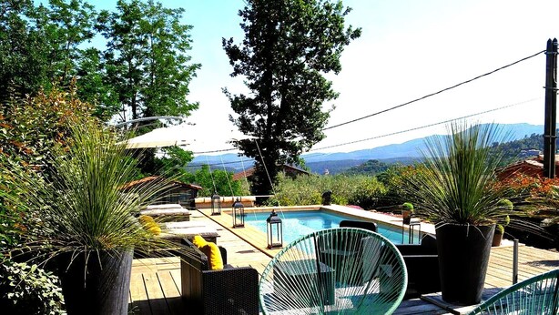 A wooden deck with a swimming pool, lounge chairs, and potted plants. - Magnificent cottage in Payzac with pool ! (PAYZAC)