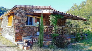 A stone house with a wooden porch and a metal railing. - Magnificent cottage in Payzac with pool ! (PAYZAC)