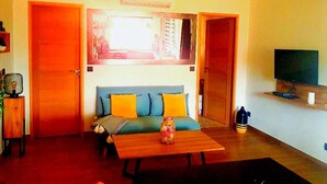 A living room with a sofa, a coffee table, and a television. - Magnificent cottage in Payzac with pool ! (PAYZAC)