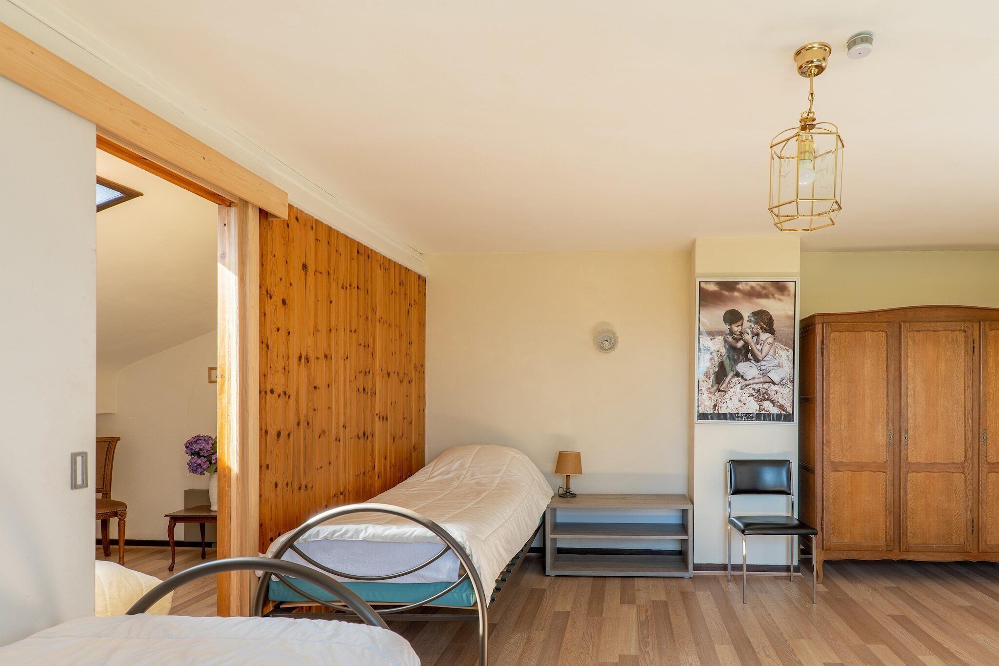 Un dormitorio con una cama, una silla, un armario y una pared de madera.