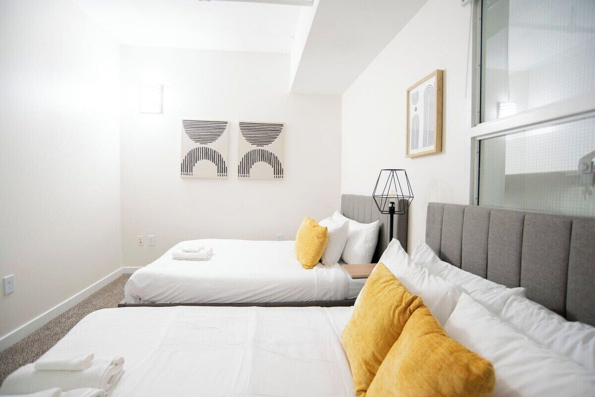 Een hotelkamer met twee bedden, een raam en wanddecoratie.