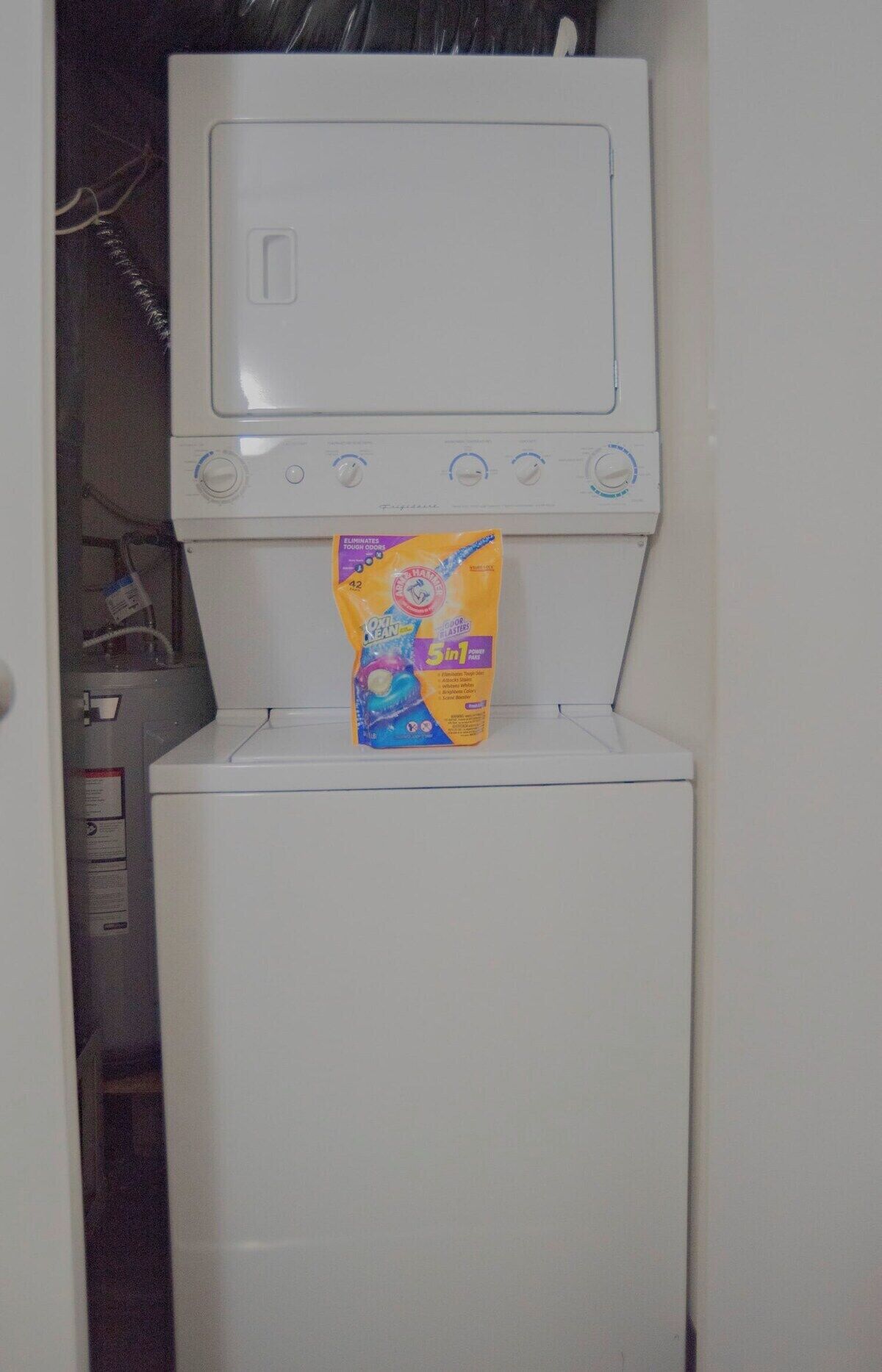Een voorlader wasmachine met een wasmiddelpakje ervoor.