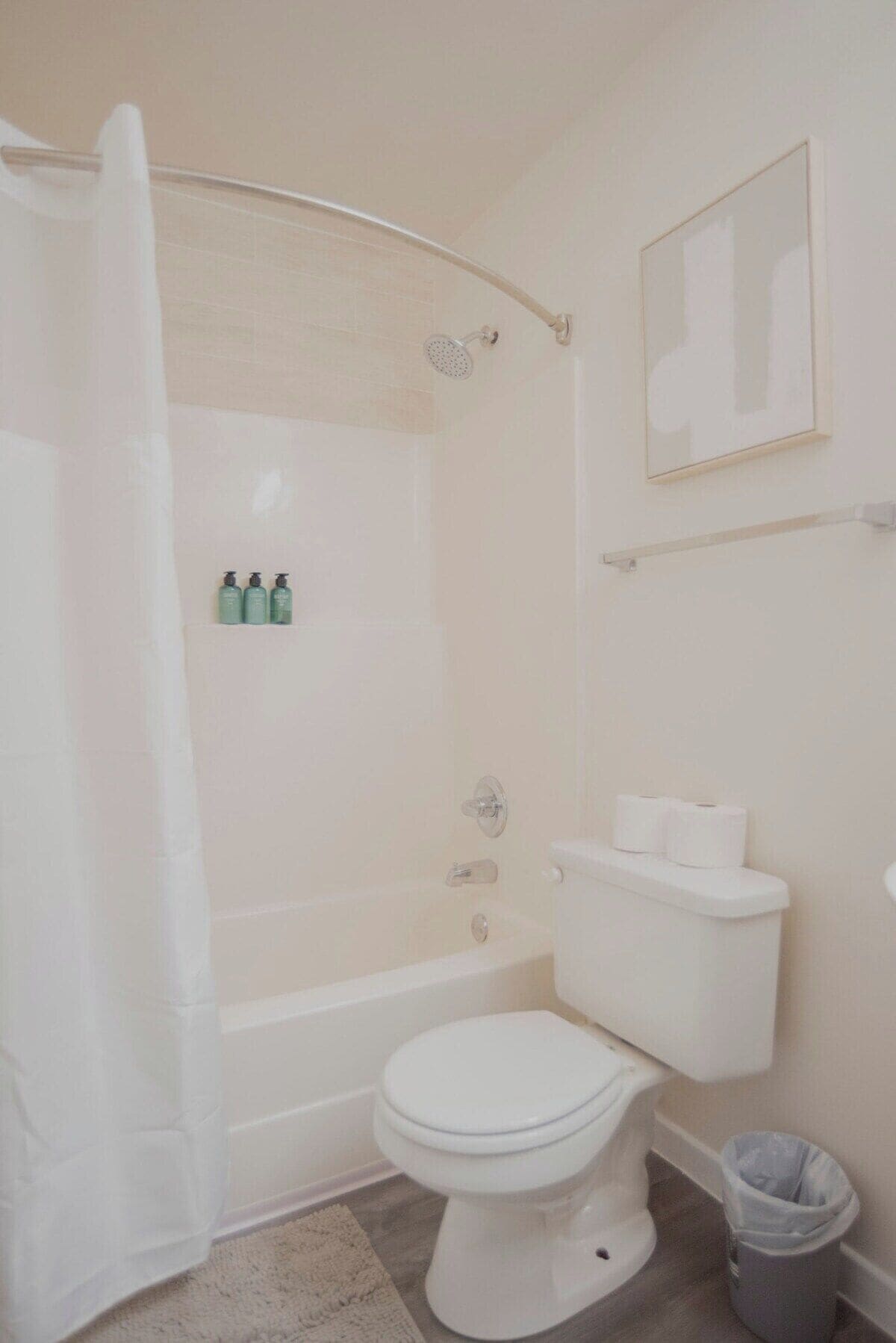 A bathroom with a bathtub, toilet, and shower curtain.