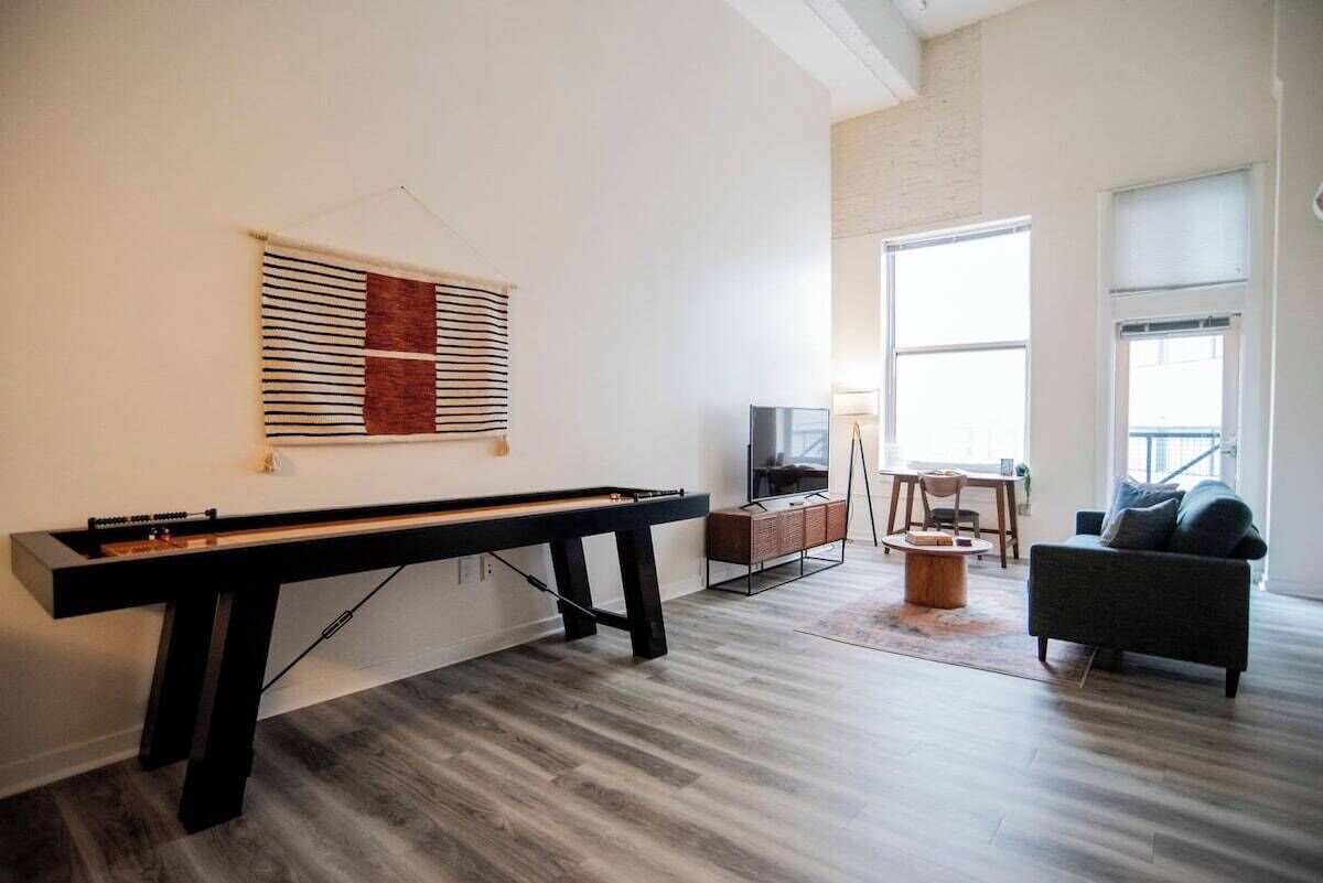 Een moderne woonkamer met een pooltafel, een flatscreen-televisie en een bank.
