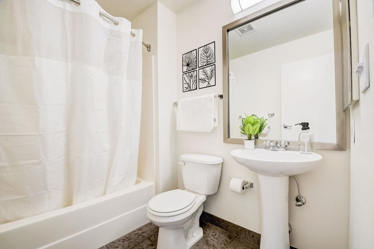 Een badkamer met een bad, toilet en wastafel.