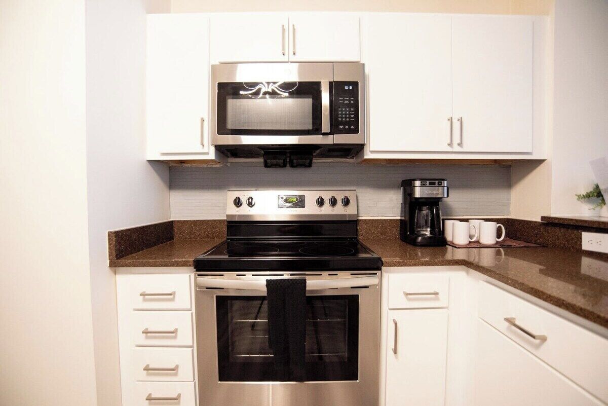 A kitchen with a microwave, stove, oven, and coffee maker.