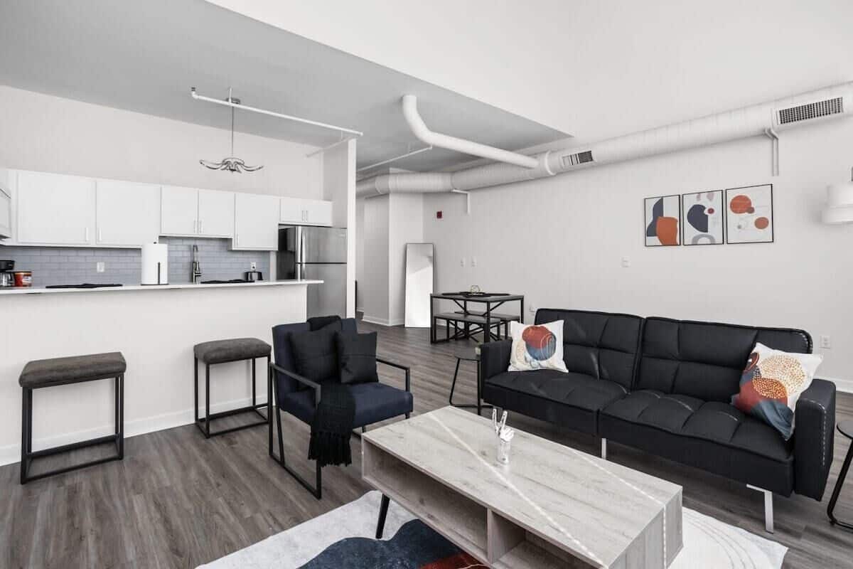 A modern apartment with a kitchen, dining area, and living room.