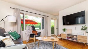 A modern living room with a sofa, a coffee table, a TV, and a bookshelf.