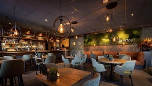 A cozy restaurant with a bar area, wooden tables, and comfortable seating. - Chalet in Brabant with Spacious Garden (Veldhoven)