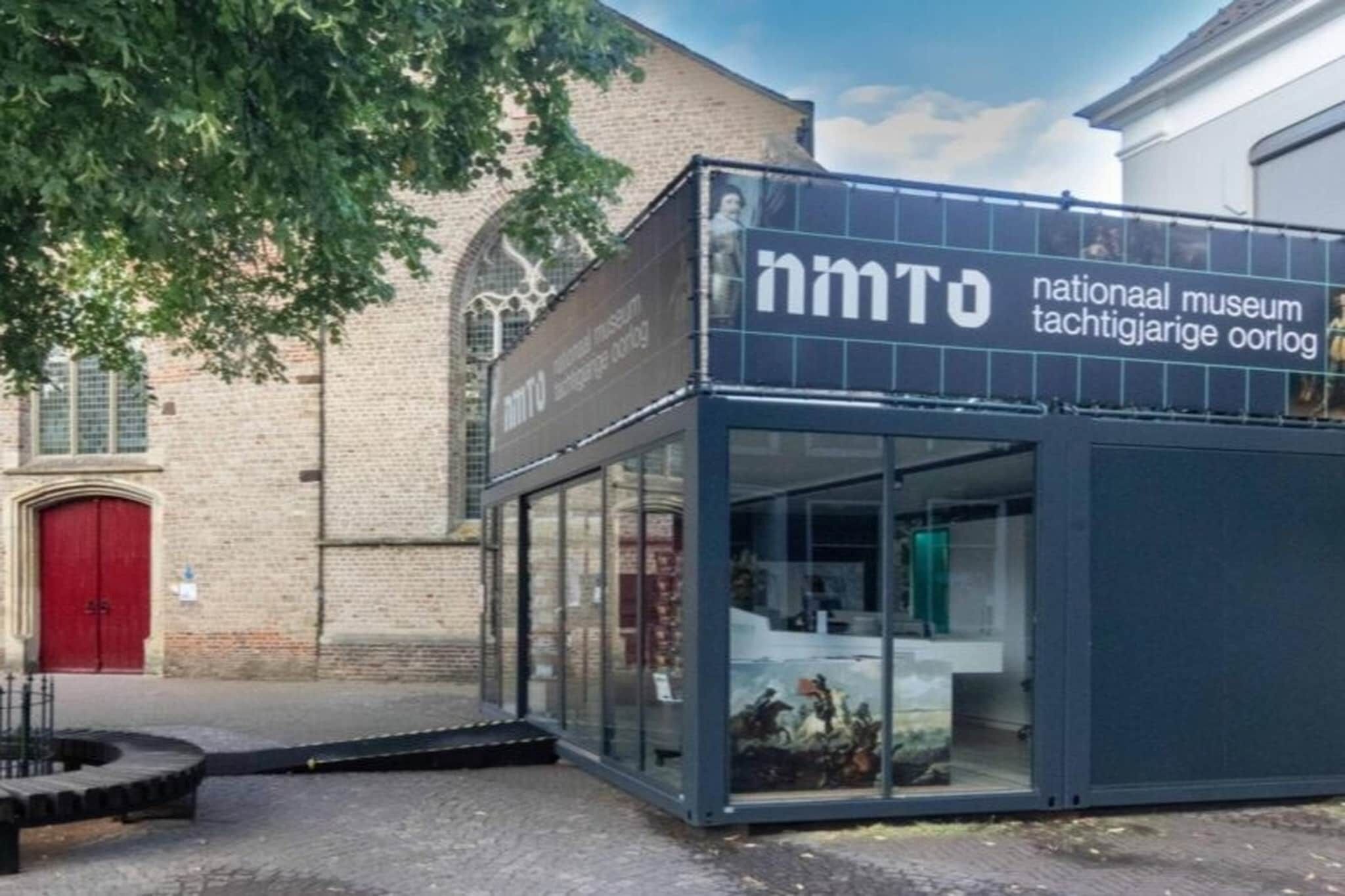 Ein modernes Gebäude mit Glasfassade und einem Schild mit der Aufschrift 'nmtO national museum'.