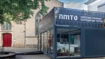 Ein modernes Gebäude mit Glasfassade und einem Schild mit der Aufschrift 'nmtO national museum'.
