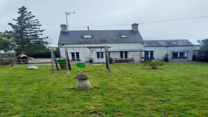 A residential property with a large lawn, a swing set, and a small garden feature. - Sunlit Garden Escape Normandy (Isigny sur Mer)