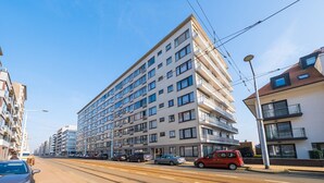 A multi-story building with a modern architectural design, featuring balconies and large windows.