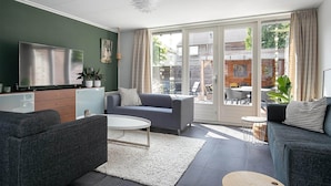 Un salon moderne avec un canapé, une table basse et un téléviseur.