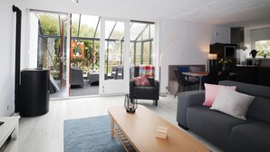 A modern living room with a grey sofa, a wooden coffee table, and a sliding glass door leading to an outdoor patio.