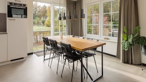 A modern kitchen with a dining area, large windows, and a view of the outdoors. - Holiday Home in Bad Bentheim with Sauna (Bad Bentheim)
