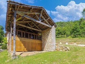 A rustic wooden building with a stone foundation, a wooden door, and a sloped roof. - Renovated farmhouse in Soturac with pool (Soturac)