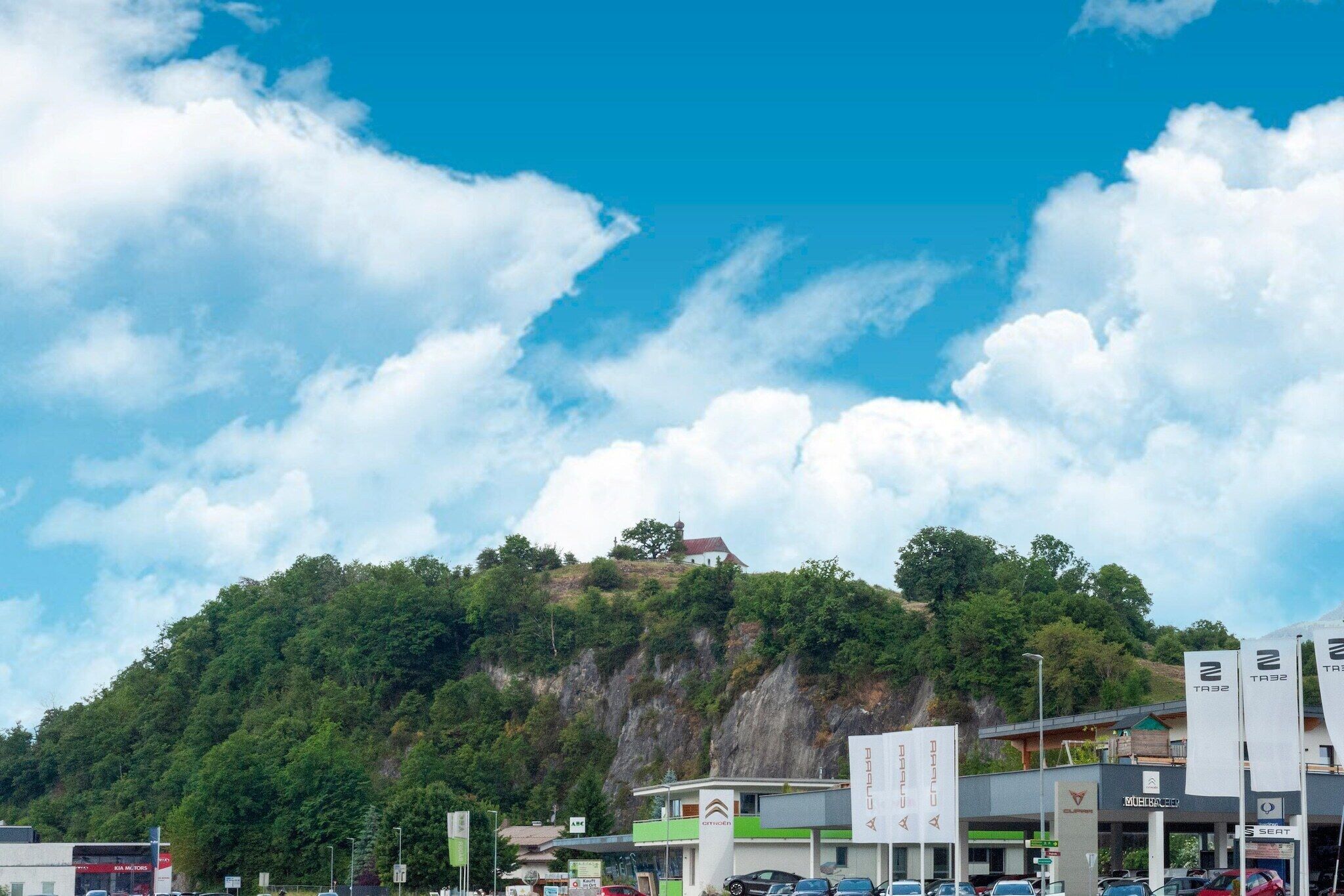 Un hôtel offrant une vue sur une colline boisée et un ciel dégagé.