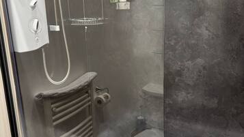 Une salle de bain moderne avec une douche à parois de verre, une baignoire blanche et un mur gris à texture.