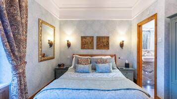 A bedroom with a wooden bed, two wall-mounted lamps, and a mirror.