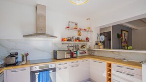 Eine moderne Küche mit weißen Schränken, einer Holz Arbeitsplatte und einem eingebauten Backofen.