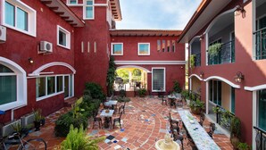 A courtyard with a tiled floor, outdoor seating, and potted plants. - Hacienda Resort Mae Phim (Klaeng)