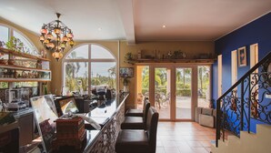 A bar area with a counter, seating, and a decorative chandelier. - Hacienda Resort Mae Phim (Klaeng)