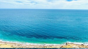 Una playa con agua azul cristalina y una orilla arenosa.